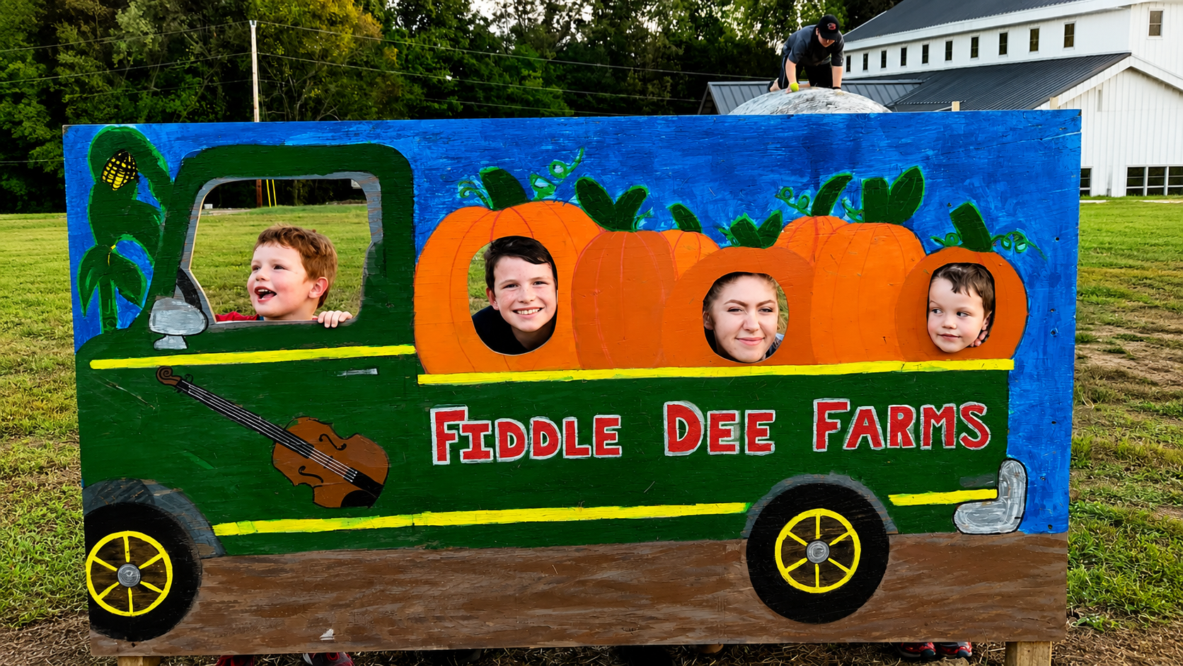 Kids posing in the Fiddle Dee Farms bus cutout photo op at Shuckle&rsquo;s in Greenbrier, TN